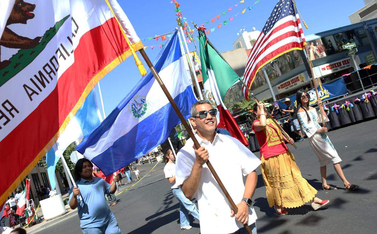 Fresno City Councilmember Miguel Arias carries the California flag during the Fiestas Patrias parade in downtown Fresno on Sept. 15, 2024.