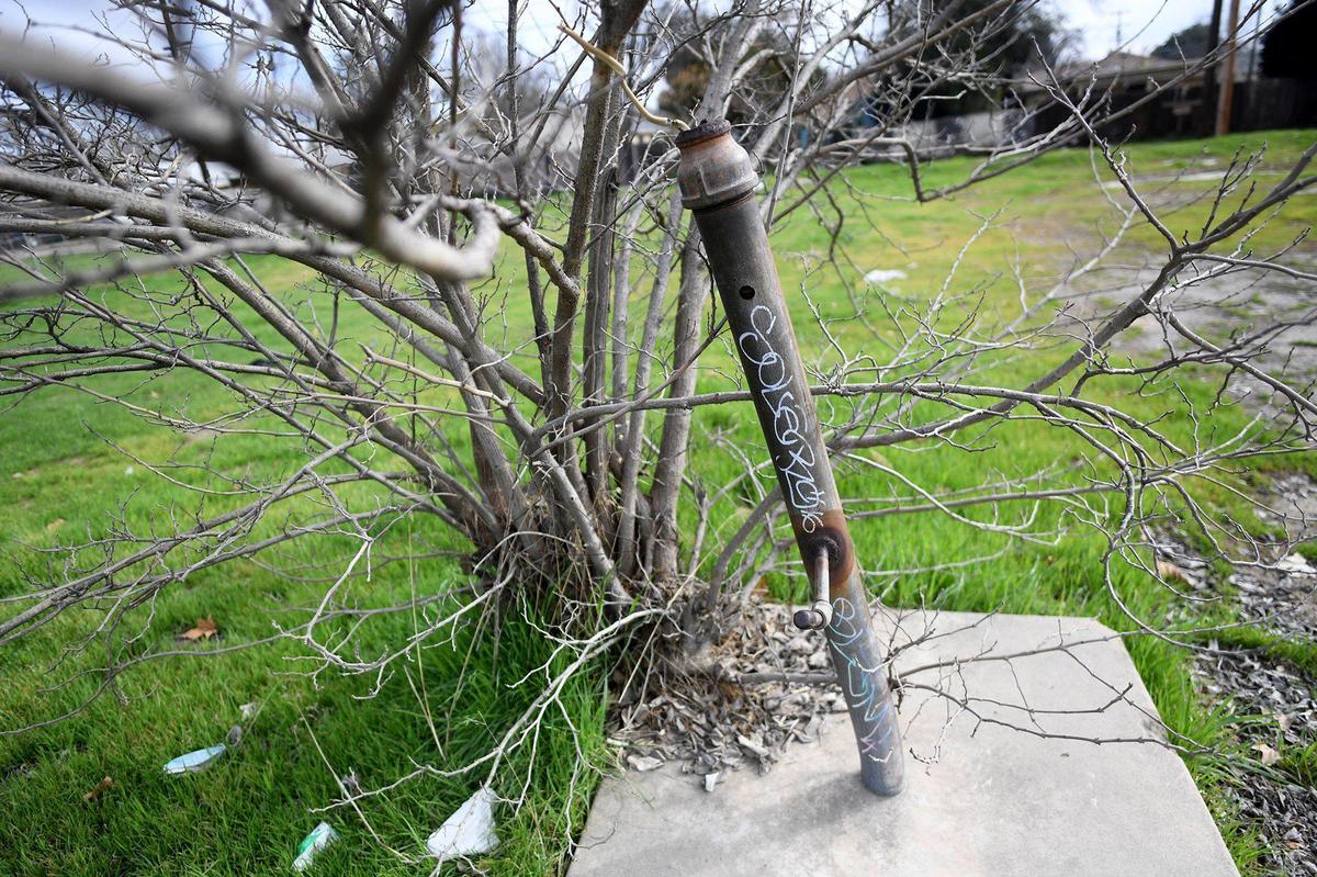 A bent utility-type pipe atop a concrete slab, on an overgrown lot, probably used for commercial purposes on Elm Avenue in southwest Fresno, Feb. 5, 2021. The area is dotted with brownfields- EPA designated land, previously used, where the presence of contaminates is known, which hinders future development without costly abatement.