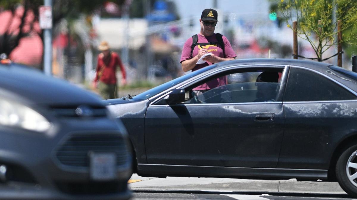 Fresno Bee columnist Marek Warszawski takes notes as he pauses at Shields Avenue on his hike south along Blackstone Avenue Wednesday, May 8, 2024 in Fresno.