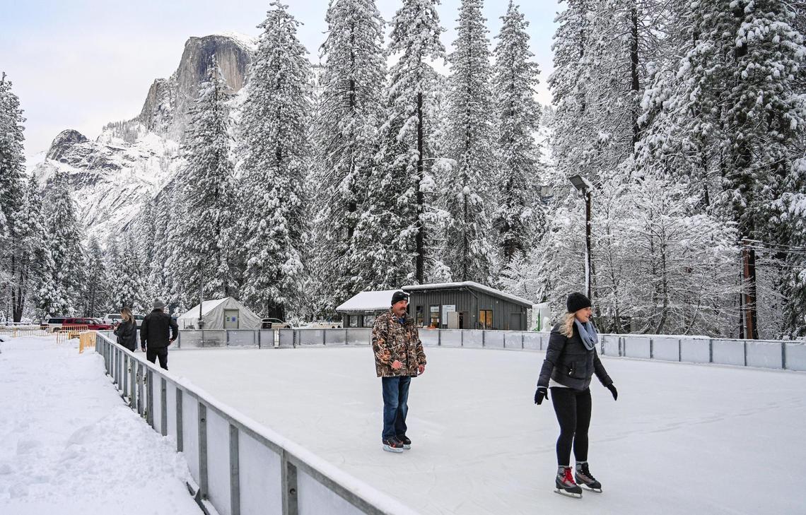 A few skaters begin to take the ice at the Curry Village ice skating rink in Yosemite Valley on Wednesday, Dec. 15, 2021, following a snowstorm the day before.
