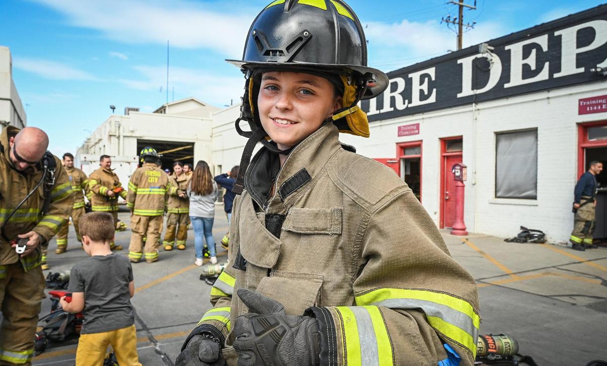 Rusty Davis, 14, of Clovis puts on a firefighter’s turnout gear during the Fresno Fire Department’s annual “Firefighter for a Day” event where citizens can get an inside look at the job of a firefighter, at the department’s training grounds in Fresno on Saturday, Oct. 22, 2022.