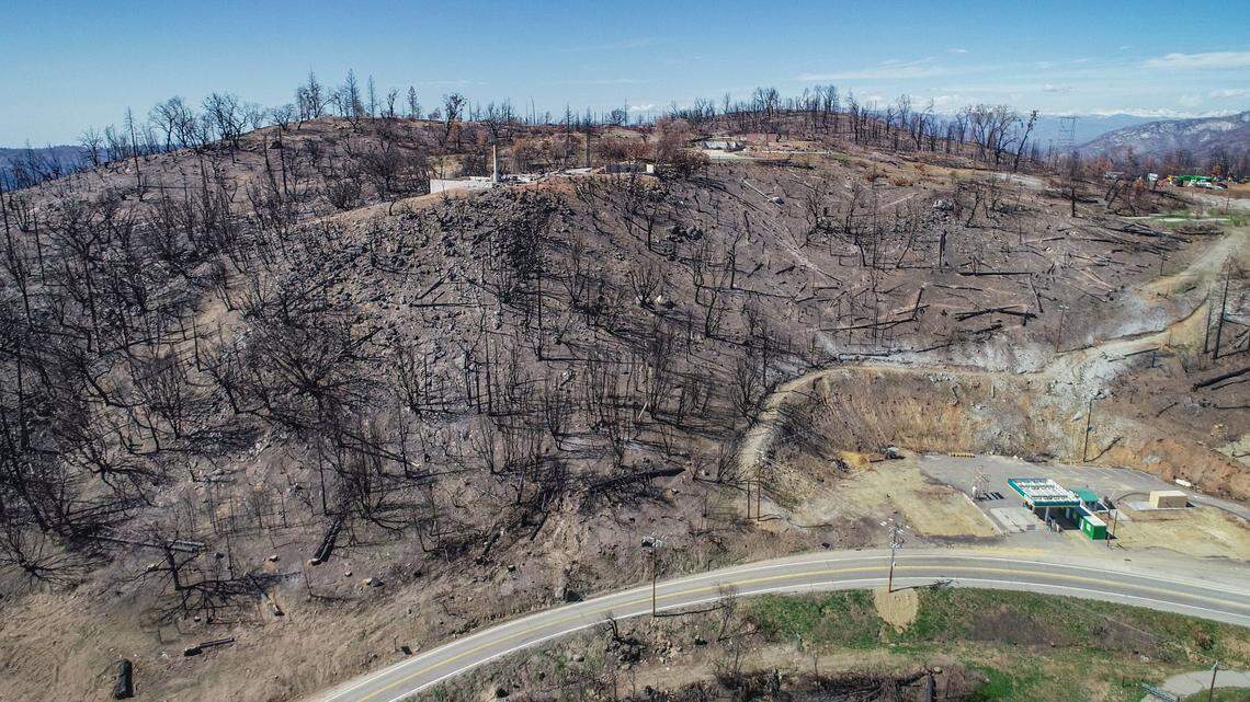 Cressman’s General Store, destroyed in last year’s Creek Fire, and the remains of its gas station appear at lower right while surrounded by mostly charred terrain along Highway 168 above the four-lane section near Pine Ridge in this drone image on Friday, April 9, 2021.