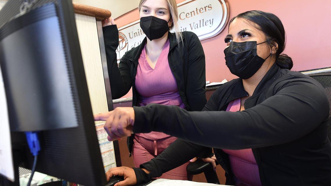 Medical assistants Grace Martinez, left, and Mary Rodriguez, go over data at Mendota’s United Health Center, April 28, 2021.