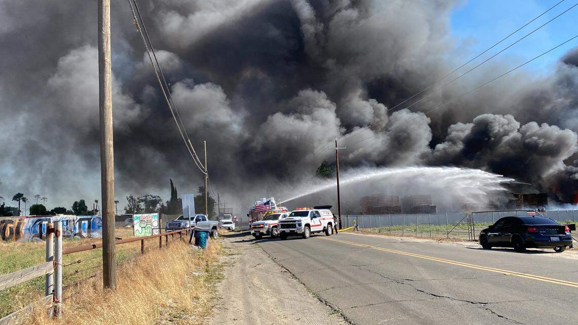Black smoke covers Cherry Avenue after a fire erupted at a business on Saturday, May 25, 2024.