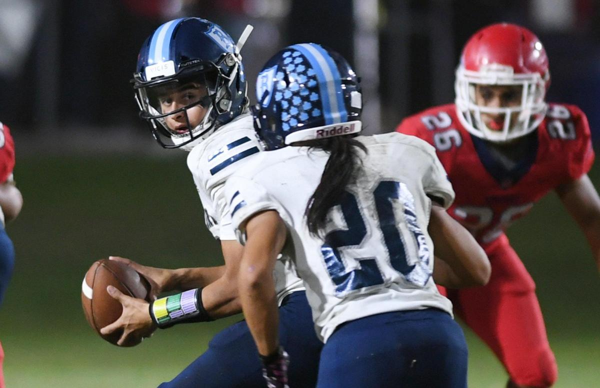 Bullard quarterback Joshua Madrigal, left, looks to handoff to Benjamin Lounbandith, right, at Tom Flores Stadium Friday, Oct. 21, 2022 in Sanger.