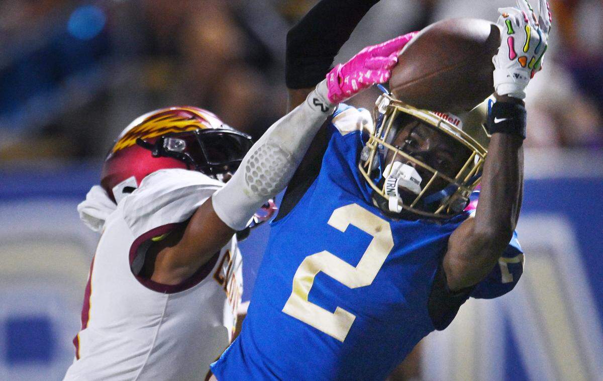 Clovis High's Carlos Young, right, nearly completes the pass covered by Clovis West's Prince Darcuiel, left, Friday, Oct. 31, 2025 in Clovis. Clovis High led 21-10 at halftime.