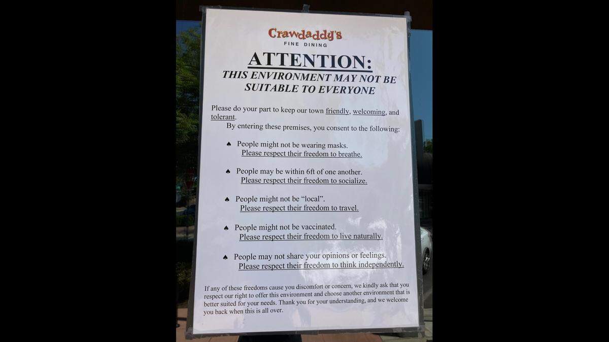 A sign in Fresno’s “Crawdaddy’s” explains their approach to visitors during the COVID pandemic.