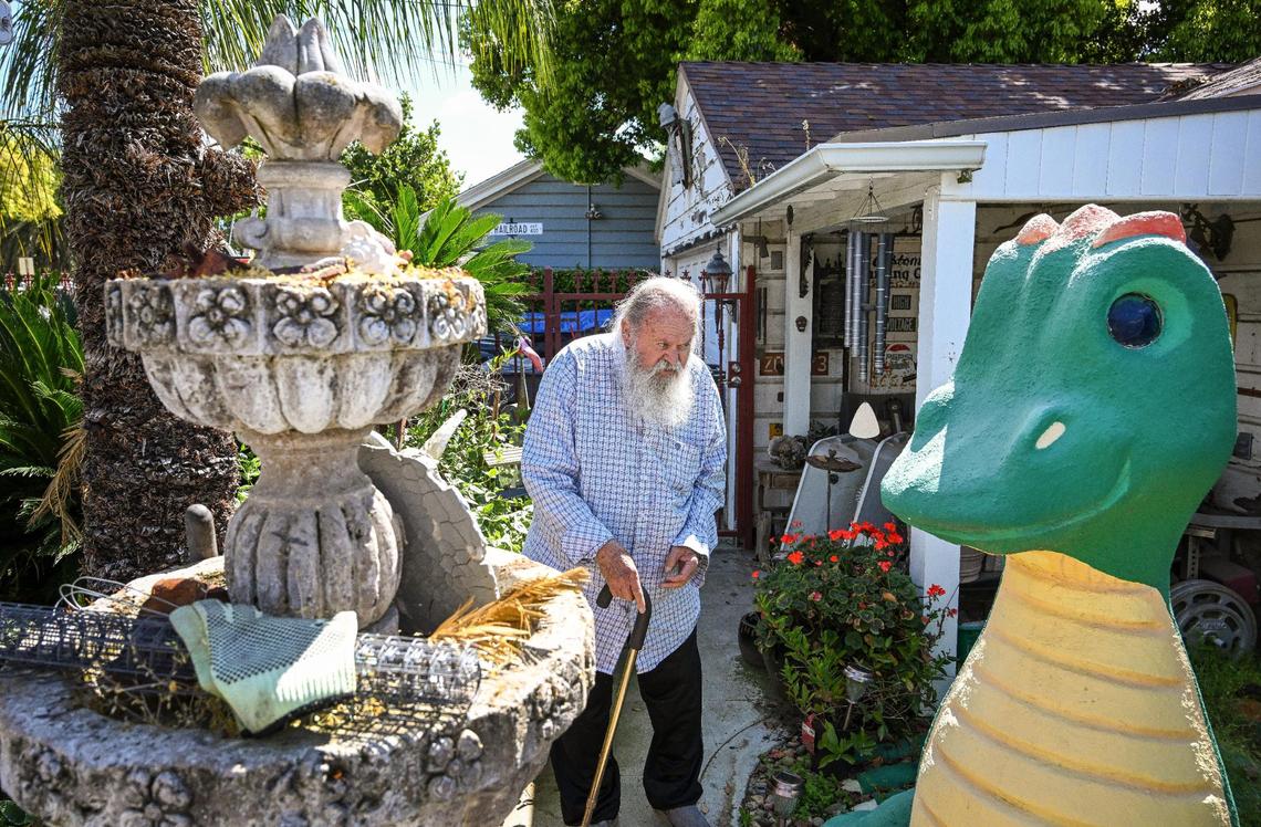 Jim Williams walks through his yard showing off old fountains and dragon sculptures in the Fresno High area where he has created an eye-catching array of art over many decades.
