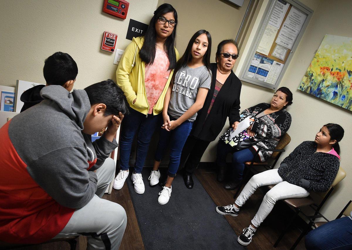 12-year-old twins Ashley, left, and Hailey Resendez, center, with grandmother Ninfa Pena, right, wait their turn to be seen for their illnesses at the United Health Center community clinic next to their school in Parlier, January 30, 2020.