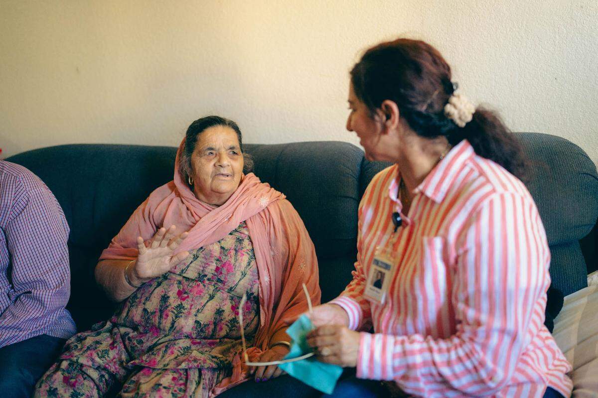 Daljit Kaur, left, speaks with Jakara Movement community health worker Harjit Kaur, who was visiting her apartment. Harjit Kaur helped Daljit Kaur and her husband, Nirmal Singh, obtain eye exams and free eye glasses.
