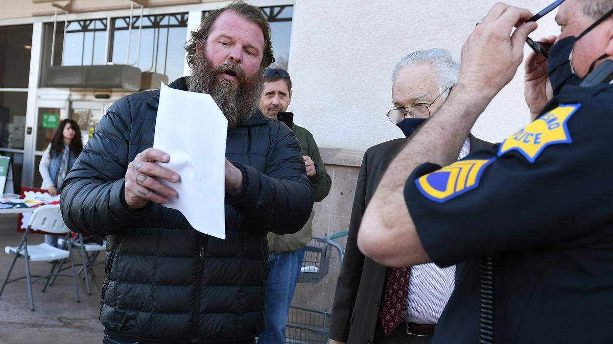 Ben Martin, left, argues his rights with Larry Donaldson, legal adviser for Fresno Police, background, outside Sprouts Farmers Market Saturday, Jan. 23, 2021 in north Fresno.