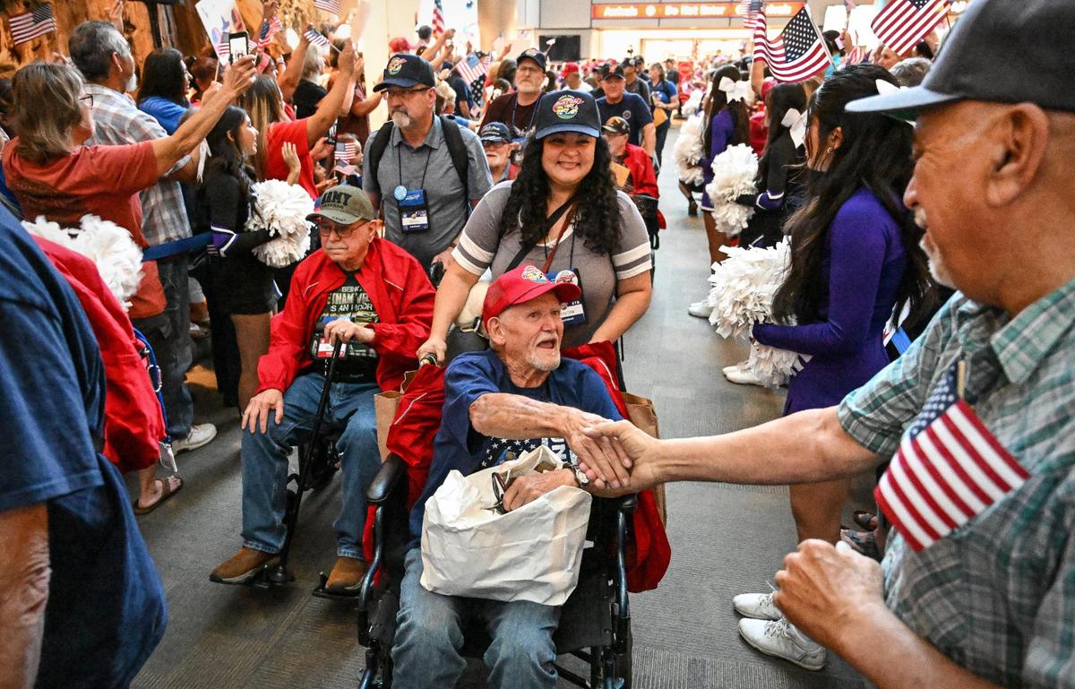 Vietnam War veteran Patrick Galle, center, of Clovis, shakes hands with welcomers as his daughter Andrea Crow wheels him past hundreds more during the Central Valley Honor Flight homecoming at Fresno Yosemite International Airport on Wednesday, May 17, 2023.
