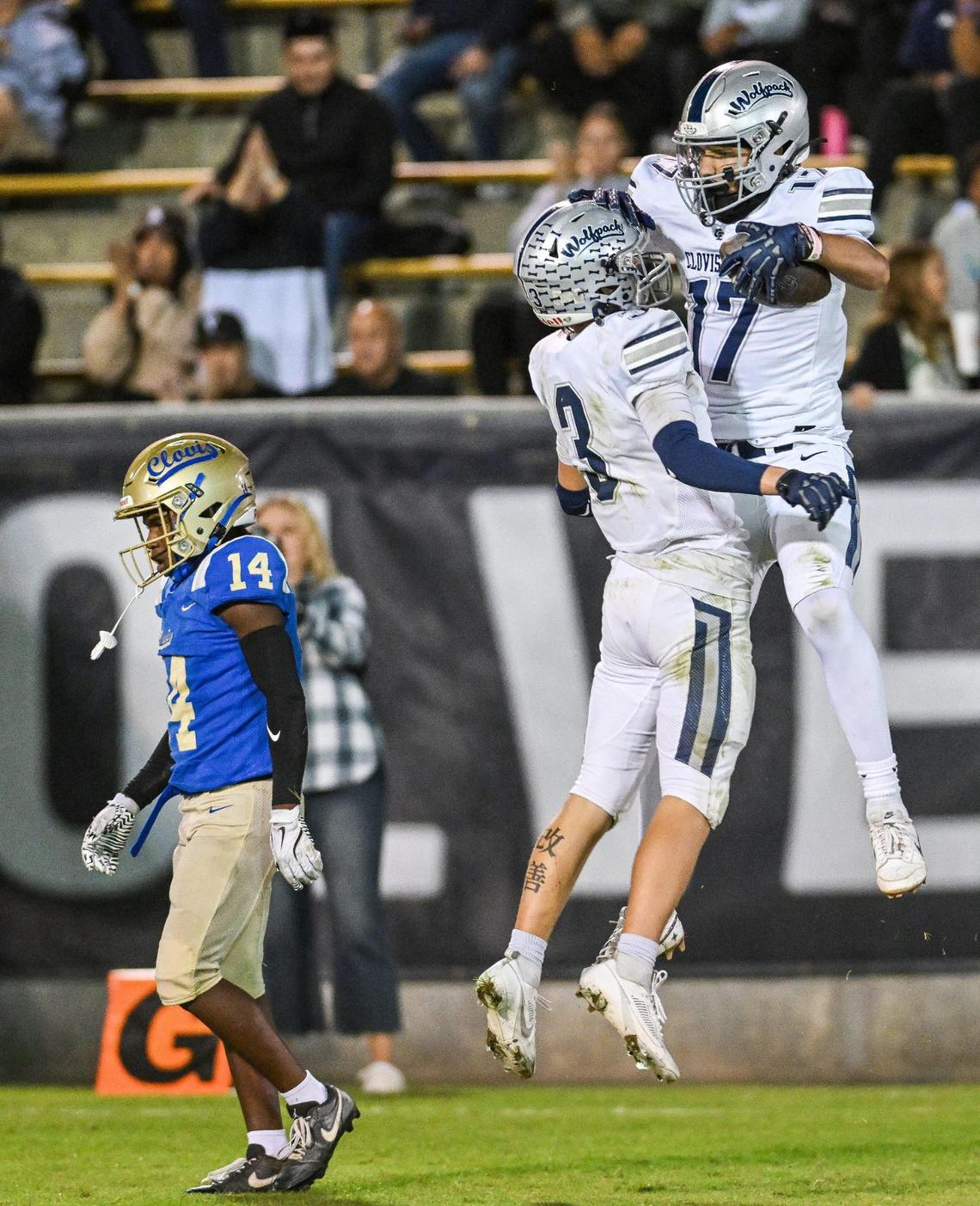 Clovis East’s Jamie Spurgeon, right, celebrates his touchdown catch with teammate Blake Mathieu while Clovis defender Sterling Edwards walks away in dejection during their game at Lamonica Stadium on Friday, Oct. 18, 2024.
