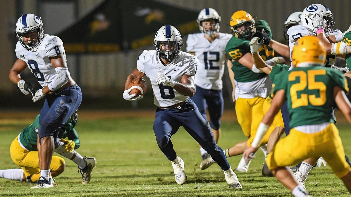 Central Valley Christian’s Bryson Donelson, center, finds a hole in the Kingsburg defense on a run up the middle during their game at Kingsburg on Friday, Oct. 14, 2022.