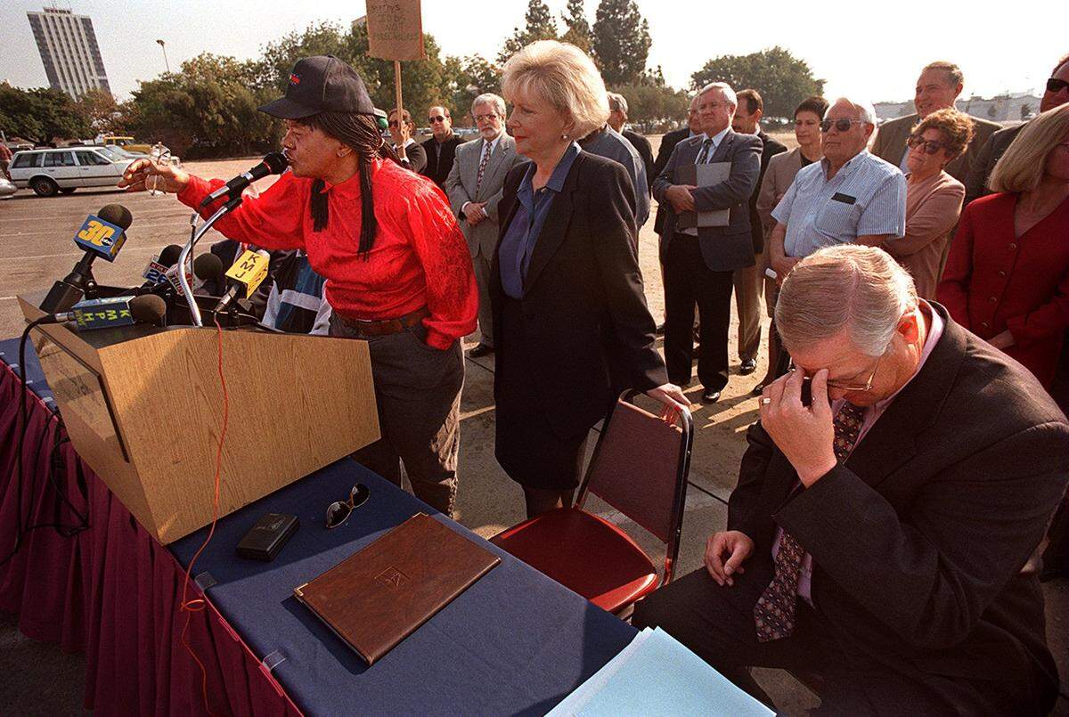 Ballpark facilitator Jerry Cook, right, rubs his brow as Barbara Hunt, left, at mike,  voices her opposition to the proposed baseball stadium downtown during a press conference with local business leaders.  Hunt feels the money should be spent on education and jobs for the area instead. Oct. 23, 1997