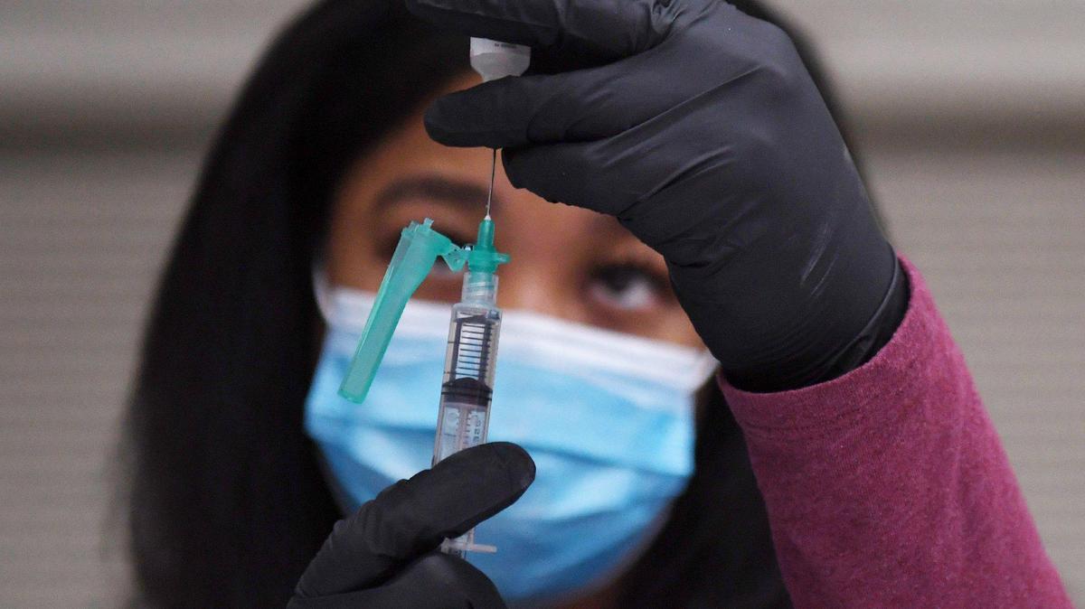 Chyna Blair, LVN, transfers the Pfizer-BioNTech vaccine to a syringe during a vaccination clinic in early 2021 at the Fresno Fairgrounds.