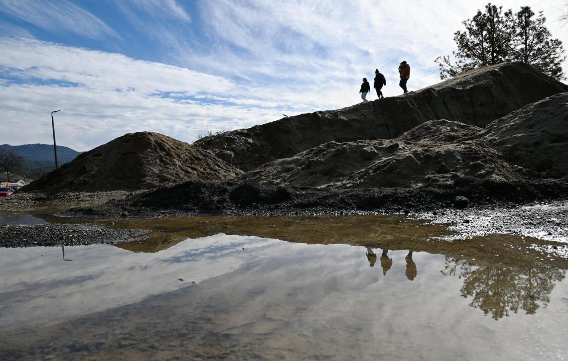 The Gamblin family from Chowchilla, who had been folowing news of the mound, descend the slope dubbed Mt. Chipotle Friday, Jan. 3, 2025 in Oakhurst. The mound located next to a new Chipotle Mexican Grill may be permanently removed in a few days but until then the community of Oakhurst and others from around the Valley are enjoying the dirt made famous in social media posts.