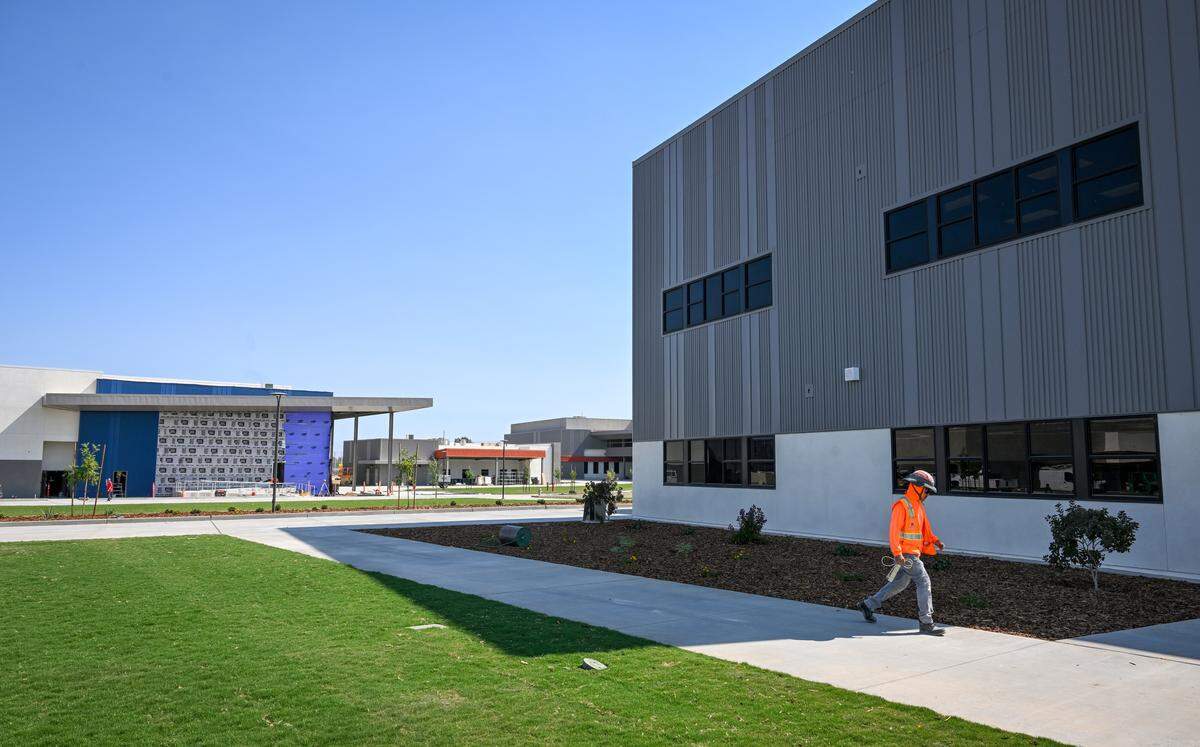 A construction worker walks near a classroom building at Phillip V. Sanchez Intermediate School, part of the Terry P. Bradley Educational Center, on Friday, Aug. 8, 2025 just days before the start of classes on August 18. 
