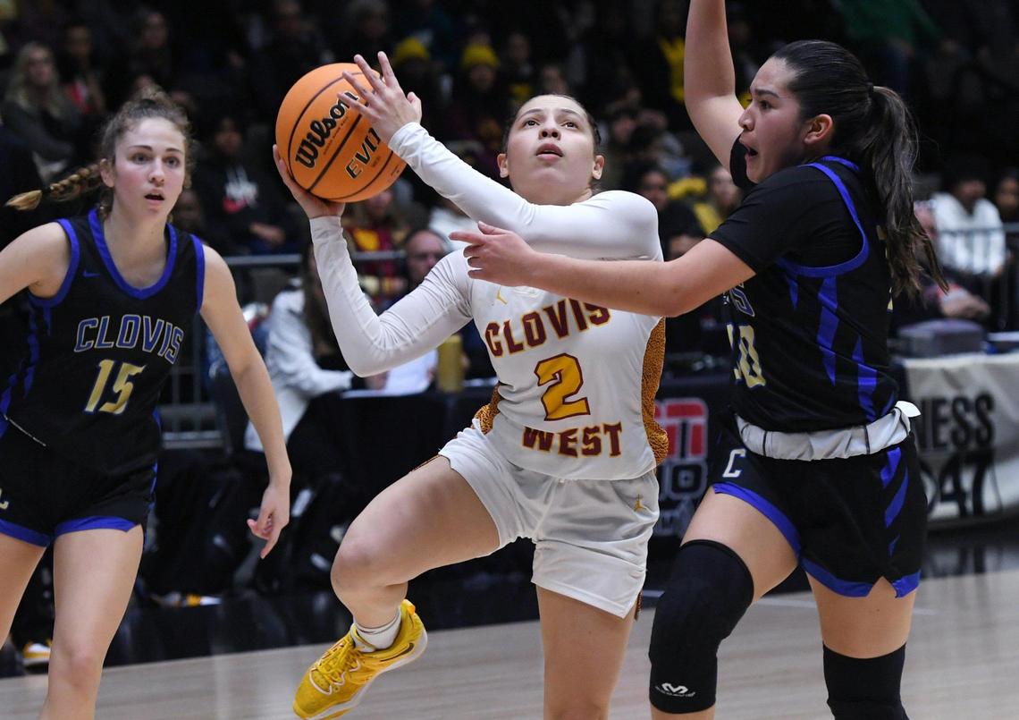 Clovis West’s Ariyah Smith, center, aims for the layup with Clovis High’s Yazmin Auilera to the right in the Central Section girls Division I basketball championship Saturday, Feb. 25, 2023 in Fresno.