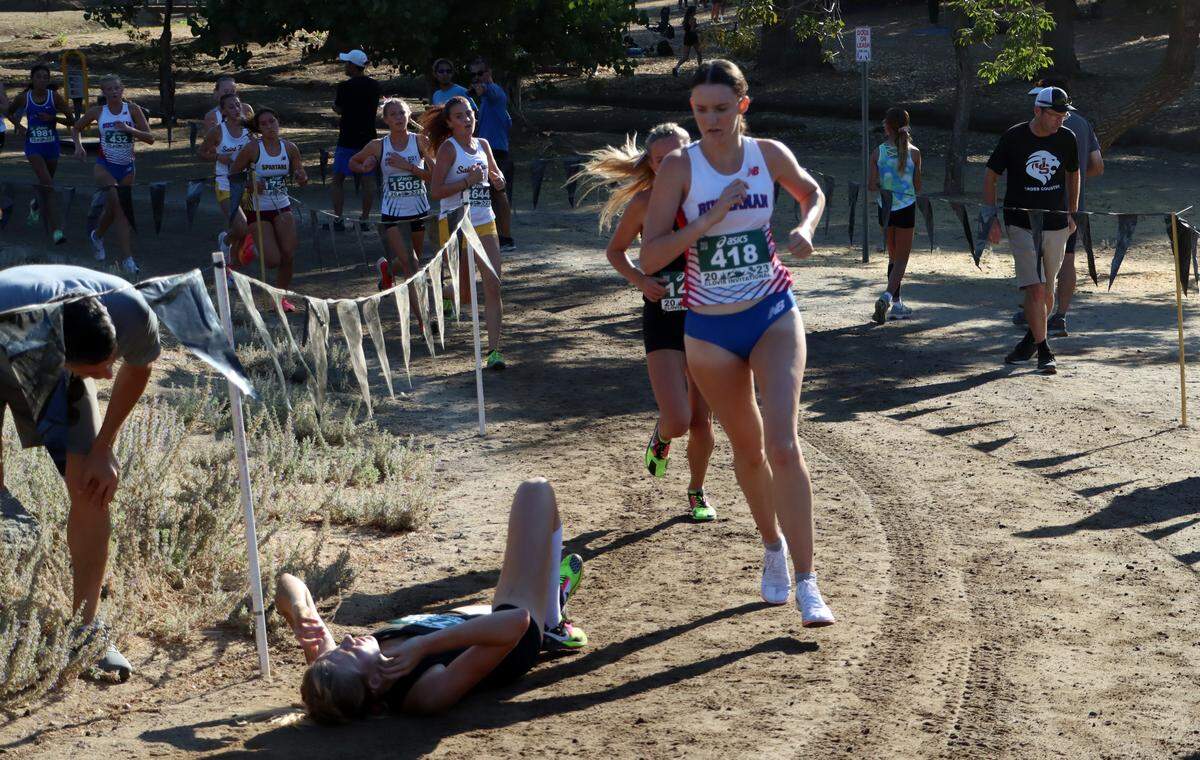 Buchanan High junior Avery Hutchison (42nd, 18:37.6) makes her way past a fallen runner during the Bill Buettner invitational flight of the 44th annual ASICS Clovis Invitational at Woodward Park on Oct. 7, 2023.