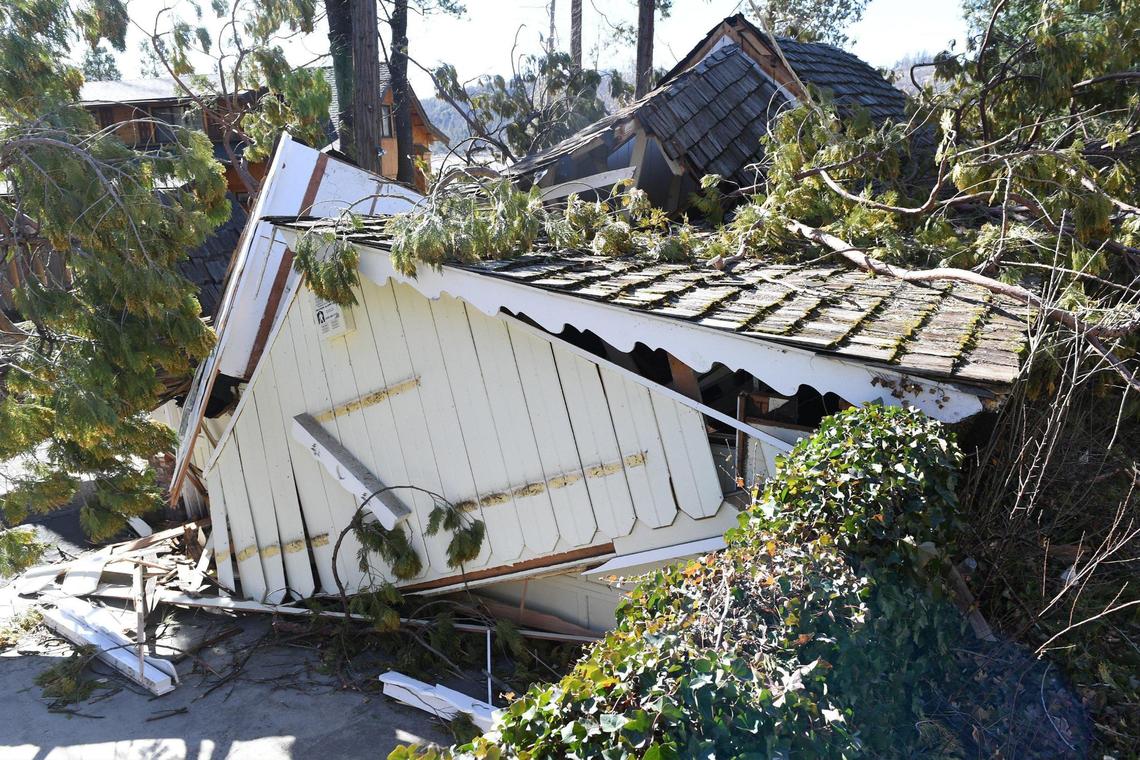 The destruction of a home crushed by falling trees is evident in the Bass Lake area after strong winds ripped through the area overnight into Tuesday, Jan 19, 2021.