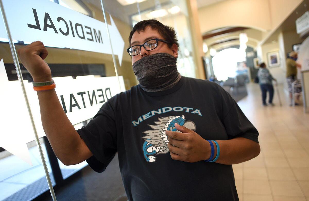 25-year-old Mendota native Kevin Arias-Romero talks about features of the United Health Center, April 28, 2021, which provides important services to the westside city’s population. He has been going to United since he was a child. Looming state changes, that would put health centers across the state, especially those in rural communities in the Central Valley, such as this one, at risk.