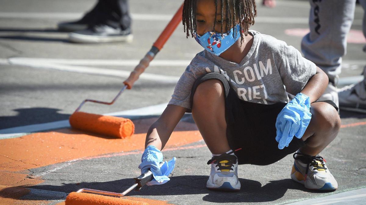 Roller in hand, 7-year-old Sheldon Archie helps paint one of the giant Black Lives Matter letters in front of Fresno City Hall on Thursday morning.