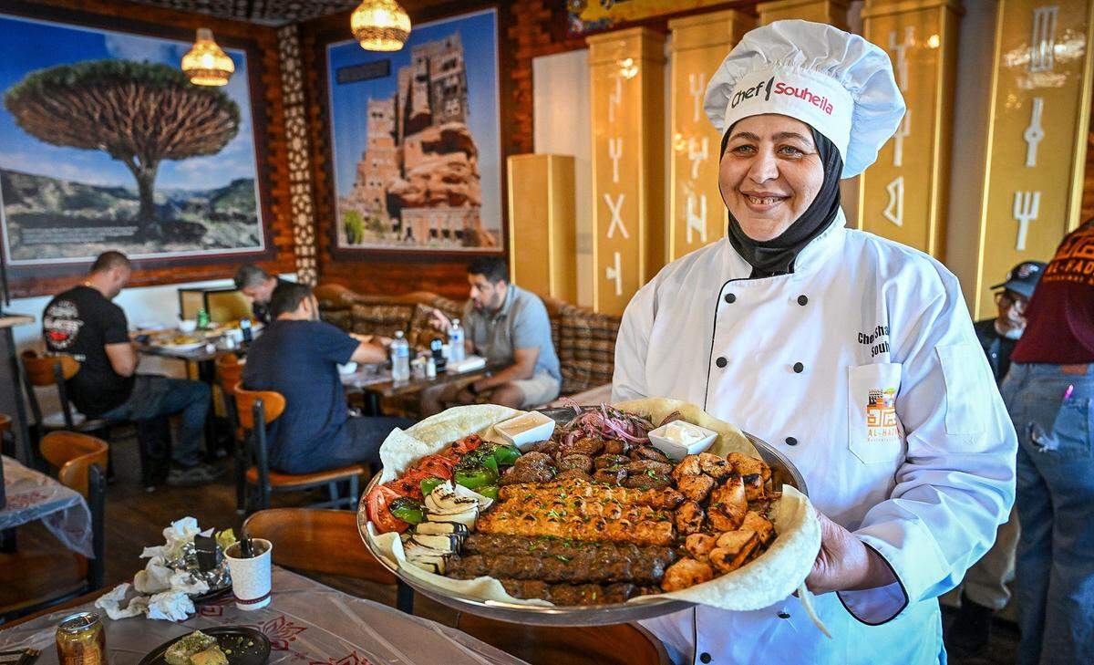 Chef Souheila Abdul Razek holds up a platter of kabobs during the grand opening of Al-Hadara Mediterranean Restaurant & Cafe located in the shopping center northeast of Blackstone and Shaw on Friday, Oct. 3, 2025.