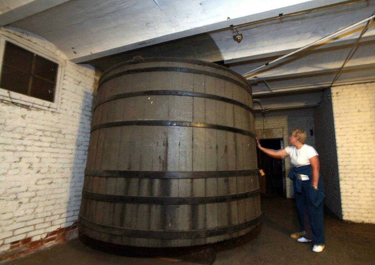 Martha Eaves, assistant to the owner of the old Fresno Brewing Company, Pat Haun, looks at a large wooden tank, in the basement of what was the bottling works, probably used in the bottle washing process in this 2010 file photo.