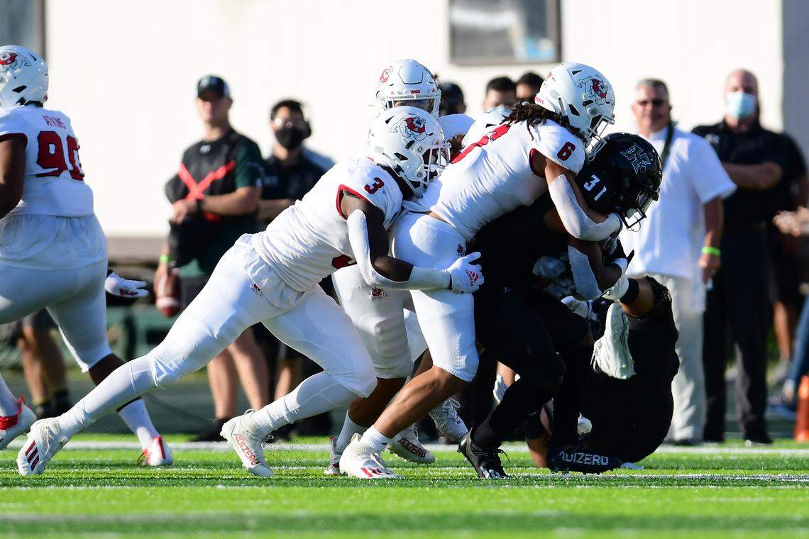Fresno State linebacker Levelle Bailey (6) and defensive end Arron Mosby (3) take down Hawaii running back Dedrick Parson in the Bulldogs’ game against the Rainbow Warriors Saturday, Oct. 2, 2021.