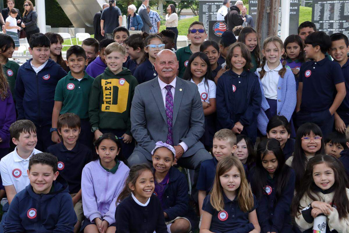 Students from the Charlie Keyan Armenian Community School in Clovis pose for a photo with Fresno Mayor Jerry Dyer during the Armenian flag raising at the annual Armenian genocide commemoration and flag-raising ceremony at Fresno City Hall on April 24, 2025.