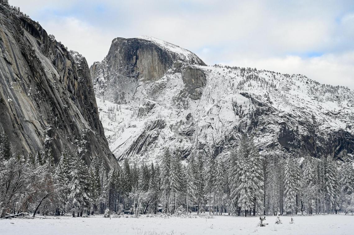 Snow covers Half Dome, the surrounding cliffs and trees in Ahwahnee Meadow in Yosemite Valley on Wednesday, Dec. 15, 2021, following a snowstorm the day before.