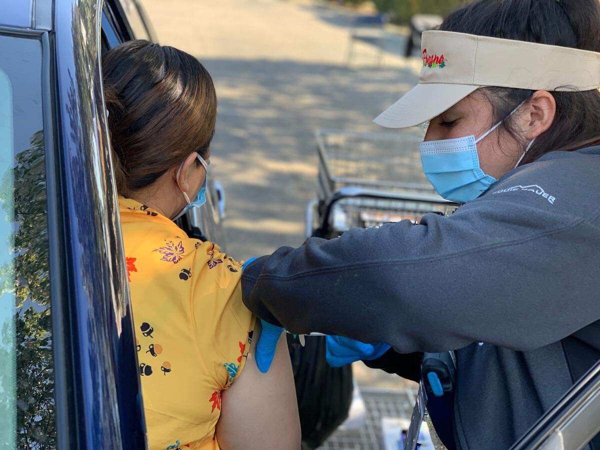Vanessa Lopez Jimenez, medical assistant with UCSF Fresno’s COVID-19 Equity Project, vaccinates a patient.