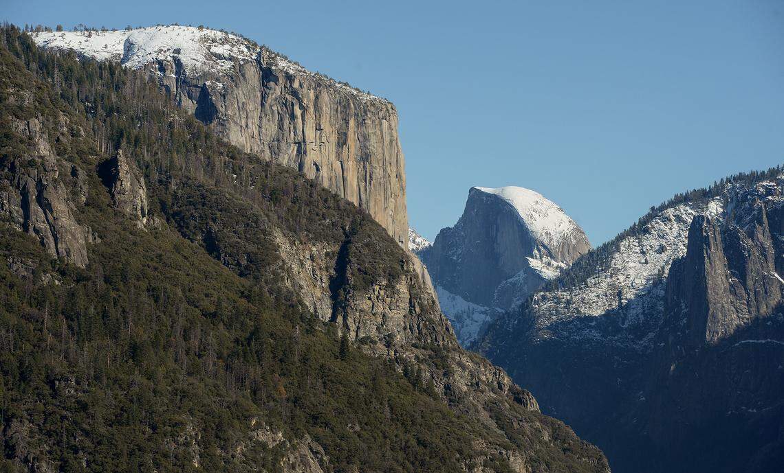 El Capitan, left, and Half Dome are visible from the Highway 41 (Wawona Road in Yosemite) entrance into Yosemite Valley after snow dusted the area on Monday, Dec. 9, 2019.