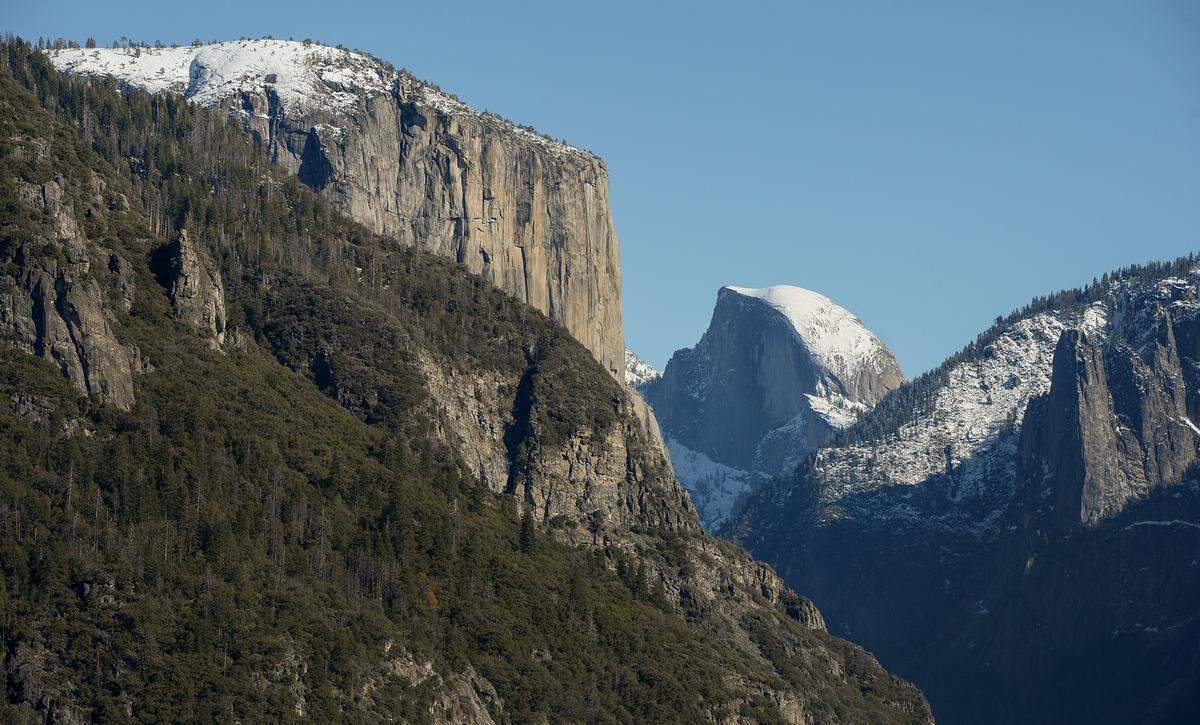 El Capitan, left, and Half Dome are visible from the Highway 41 (Wawona Road in Yosemite) entrance into Yosemite Valley after snow dusted the area on Monday, Dec. 9, 2019.