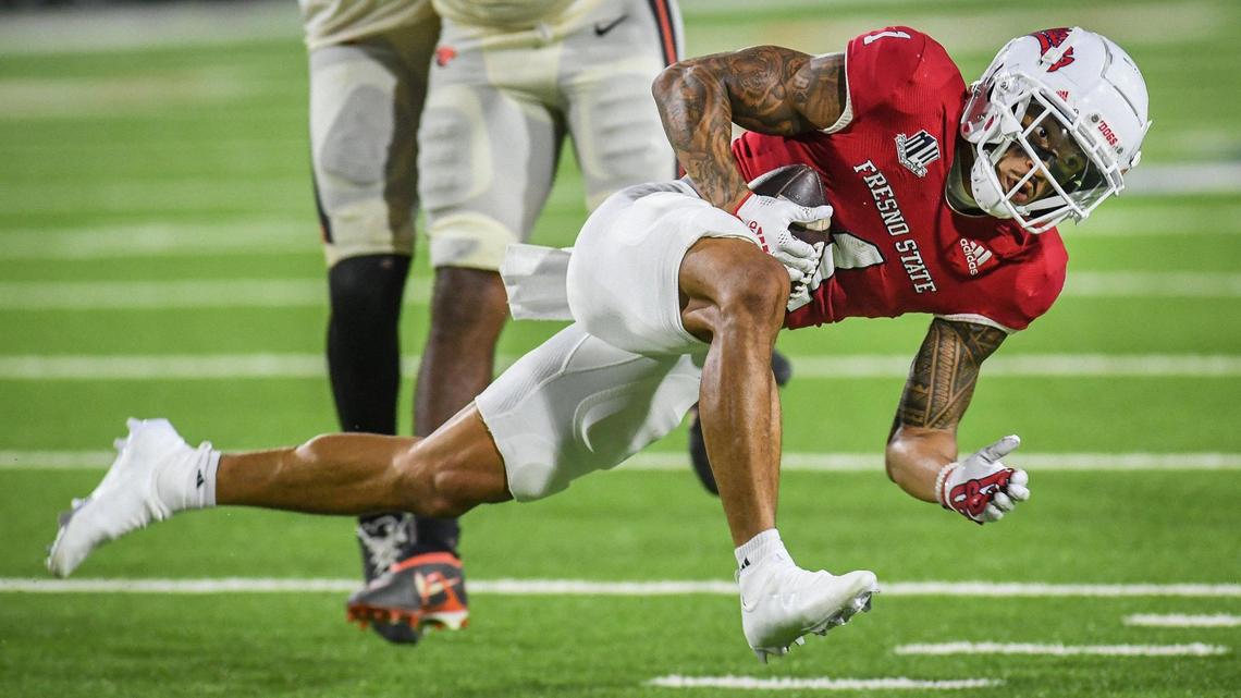 Fresno State’s Nikko Remigio lunges forward for a few more yards against Oregon State in the first half of their game at Valley Children’s Stadium in Fresno on Saturday, Sept. 10, 2022.