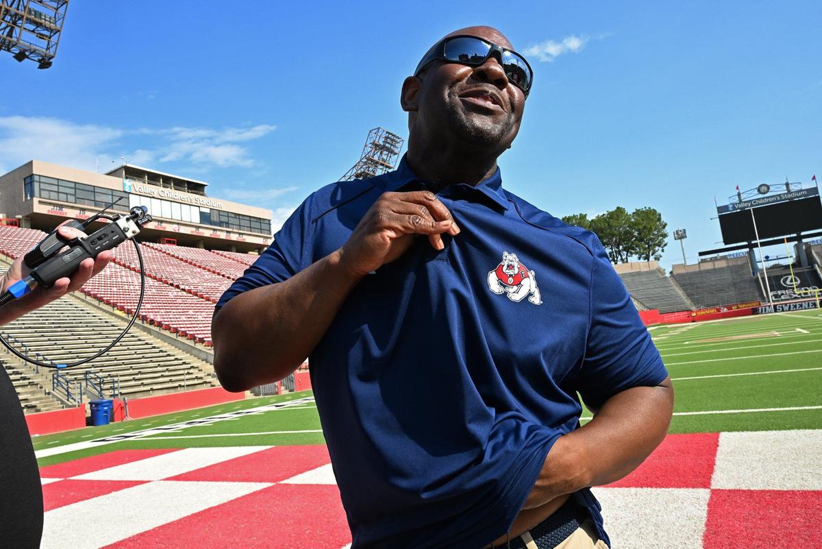 Tim Skipper laughs as he removes microphones after his first appearance with the media as Fresno State’s interim head football coach Wednesday morning, July 24, 2024 in Fresno.