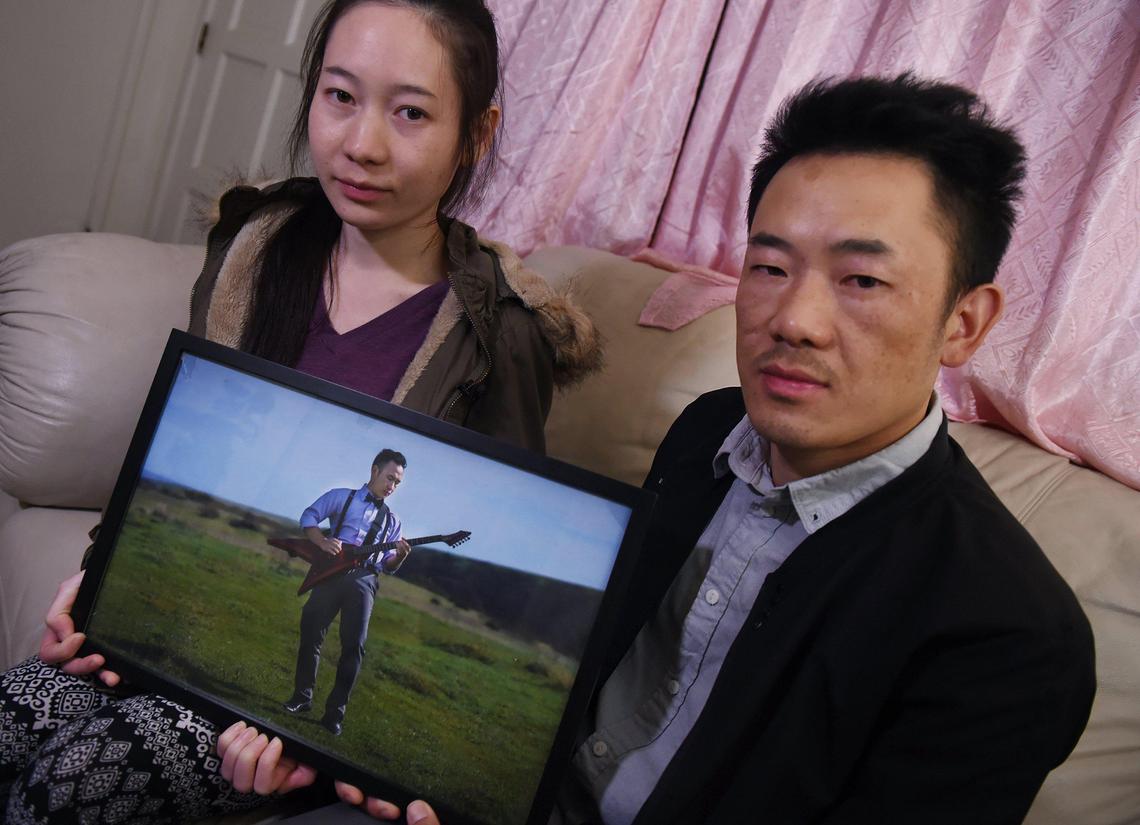 Kaonor Lee, left, and Kou Lee, right, hold a framed photo of their brother Xy Lee Tuesday, Nov. 26, 2019 in Fresno. Xy Lee, who had thousands of YouTube followers for his music videos, was killed in a mass shooting November 17, 2019 in Fresno.