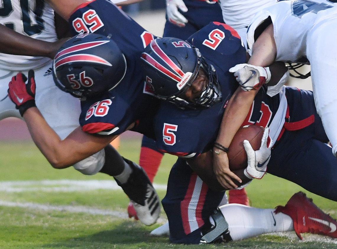 San Joaquin Memorial’s Jordan Hornbeak, bottom, extends himself to cross the end zone on Friday, April 9, 2021 in Fresno. The Panthers won 29-2.