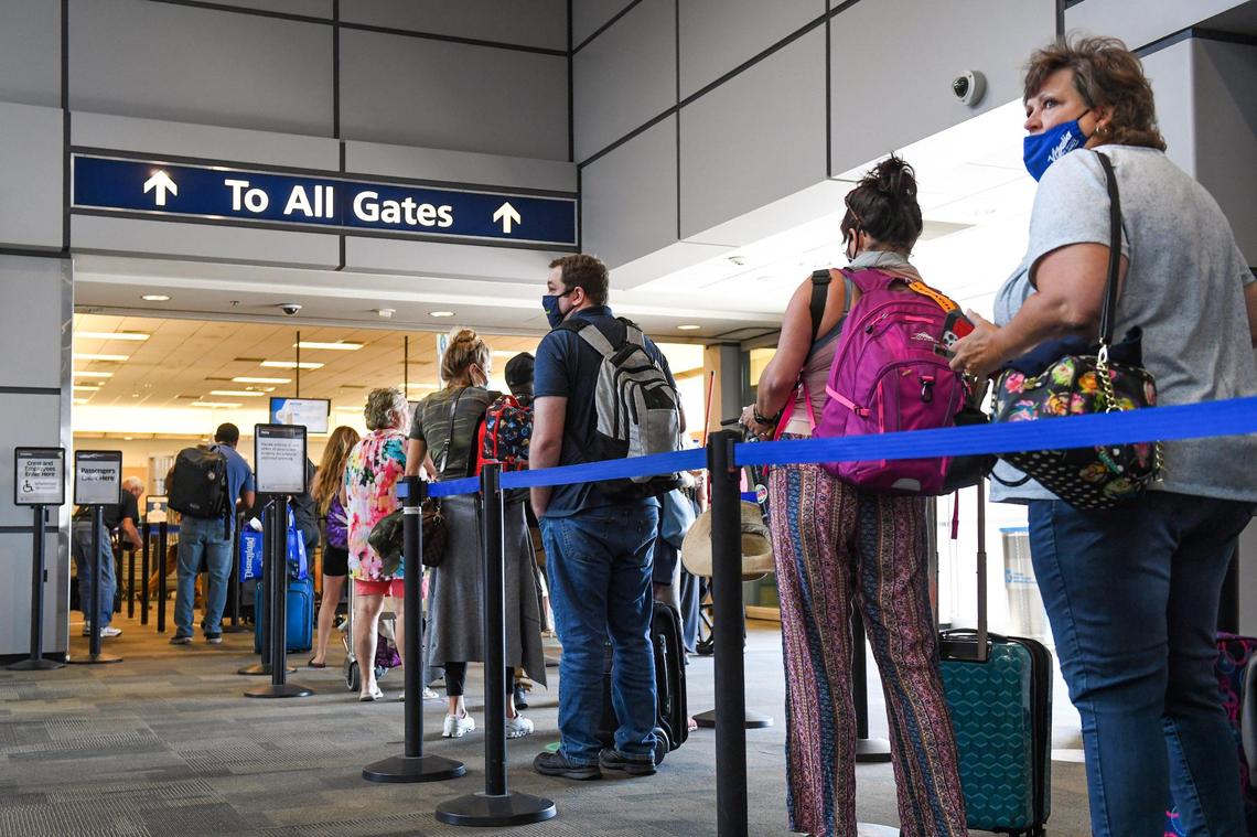 Passengers wait in line to go through the TSA security checkpoint at Fresno Yosemite International Airport on Tuesday, June 29, 2021. Air travel has picked up in recent months and even surpassed pre-pandemic levels at the airport.