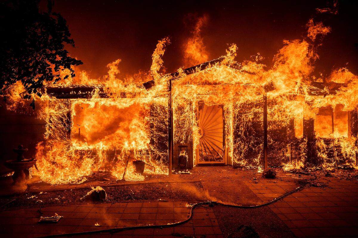 Flames consume a home on Triangle Road as the Oak Fire burns in Mariposa County, Calif., on Saturday, July 23, 2022.