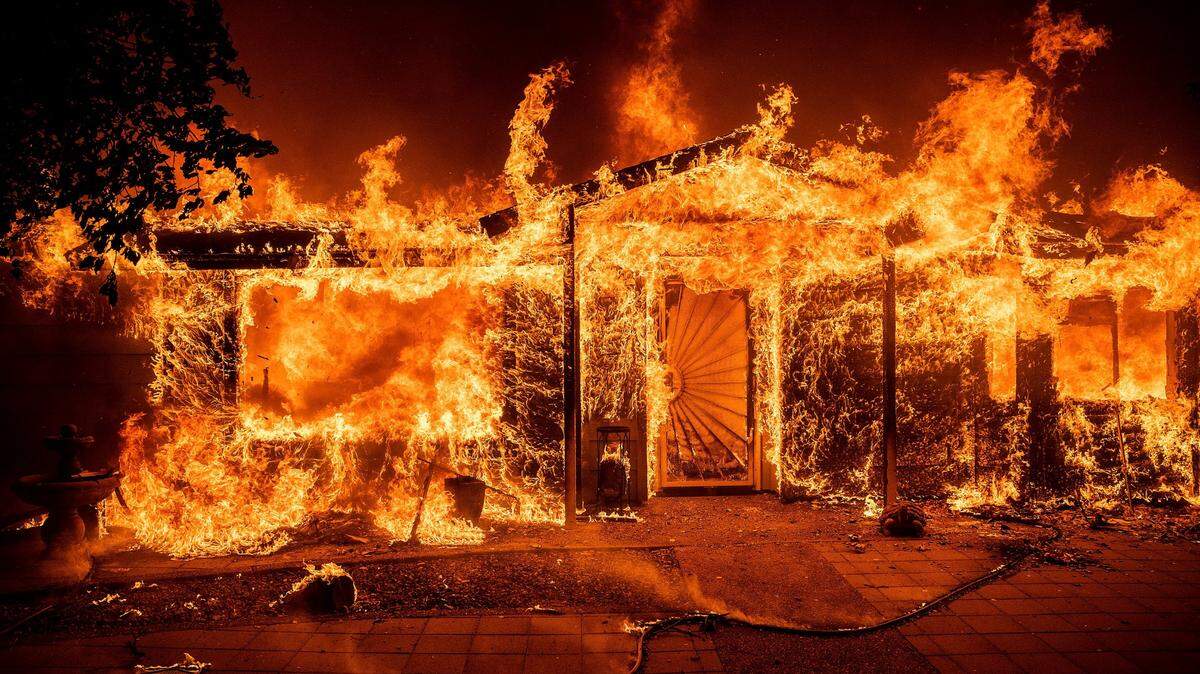 Flames consume a home on Triangle Road as the Oak Fire burns in Mariposa County, Calif., on Saturday, July 23, 2022.
