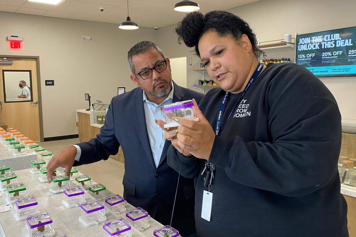Fresno Councilmember Miguel Arias gets a lesson on cannabis flower from Ivy Merriman, the store’s buyer, on Monday July 11, 2022, at Embarc, the first cannabis store to open in the city.