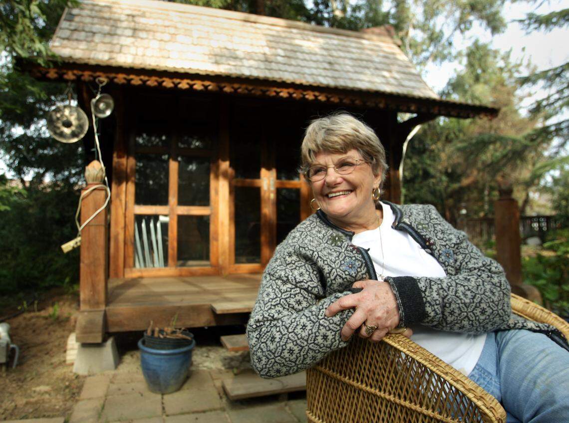 In this Bee file photo, Pat Wolk sits near her meeting/concert house in the so-called Wolk Garden where she hosts concerts for the Fresno Folklore Society.