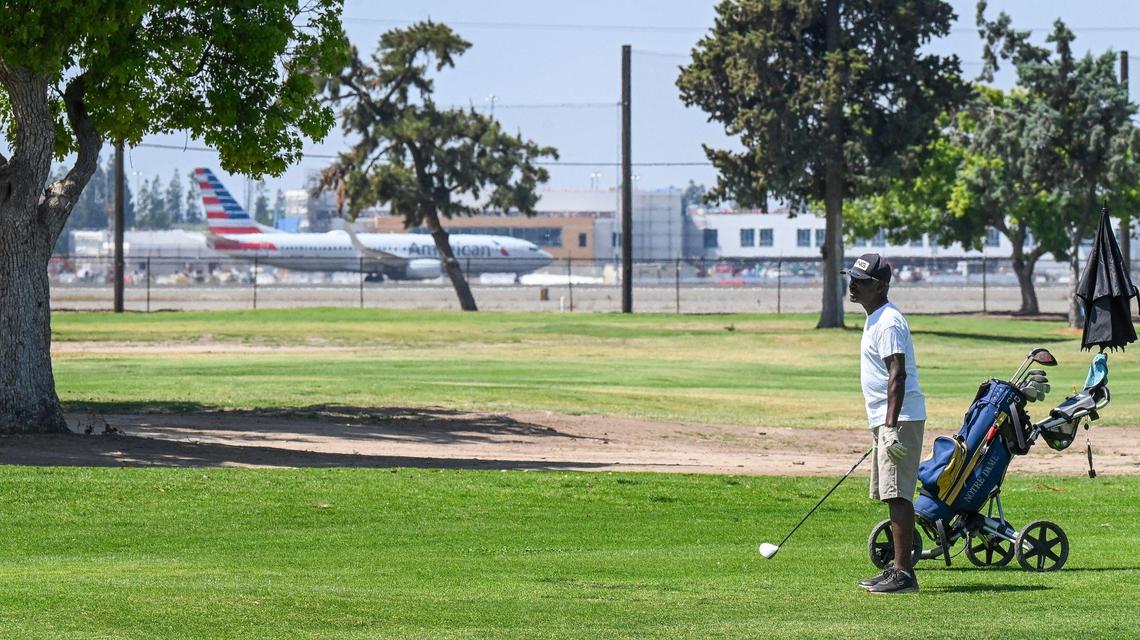 A golfer eyes his next shot at Airways Golf Course as a commercial jet taxies by at the adjacent Fresno Yosemite International Airport in Fresno on Thursday, May 1, 2025.