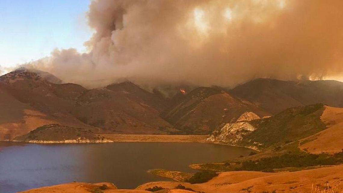 Smoke from the Alamo Fire rises into the air east of Santa Maria and the Twitchell Reservoir. The blaze grew to nearly 24,000 acres Sunday morning at 10 percent containment.