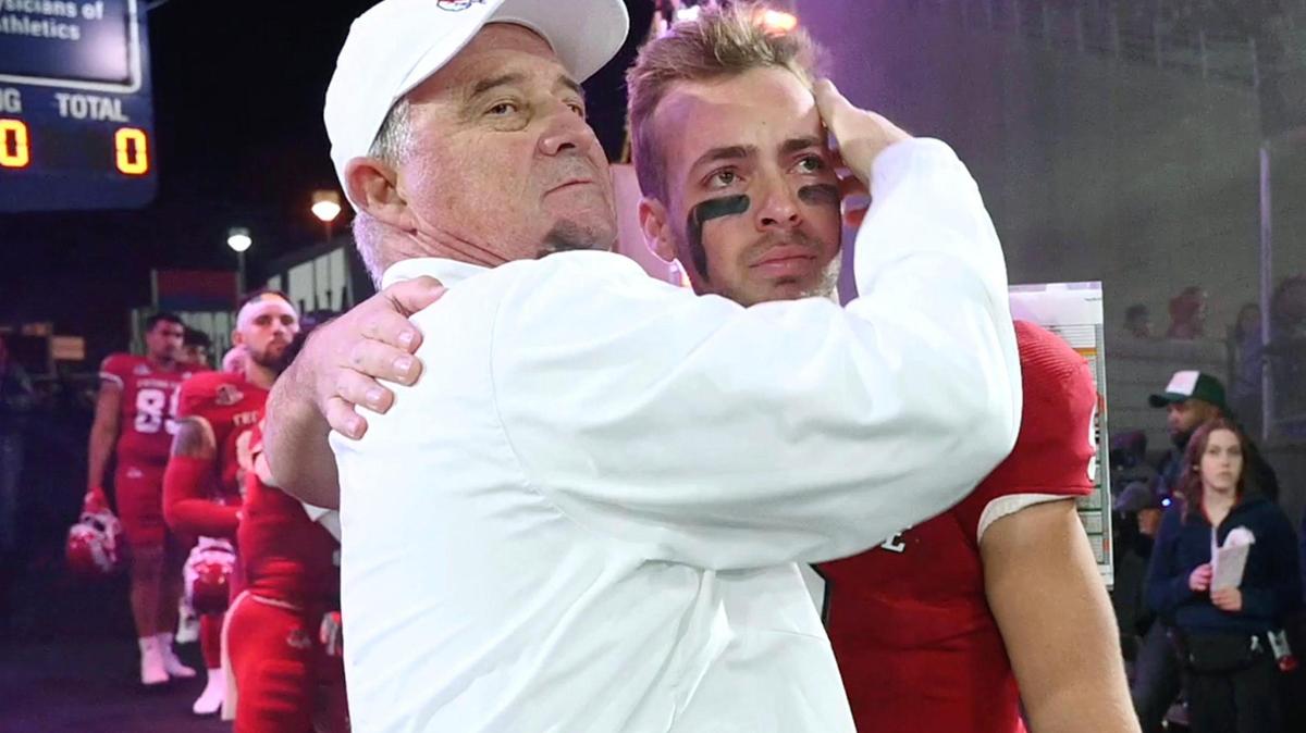 Fresno State coach Jeff Tedford embraces a tearful Jake Haener before the game against Wyoming on Friday, Nov. 25, 2022 at Valley Children’s Stadium. The record-setting quarterback was one of 13 Bulldogs honored on Senior Night before Fresno State shut out Wyoming 30-0.