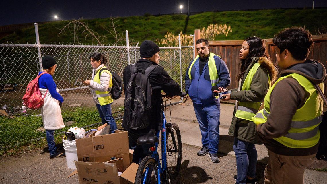 Homeless survey volunteers, from right, Joe Hinojosa, Charlen Smith, Zee Patel and Aimee Bird, gather survey information from a couple of homeless people living in the Lowell neighborhood of Fresno during the Point-in-Time homeless count hosted by the Fresno Madera Continuum of Care, on Wednesday, Jan. 29, 2020.