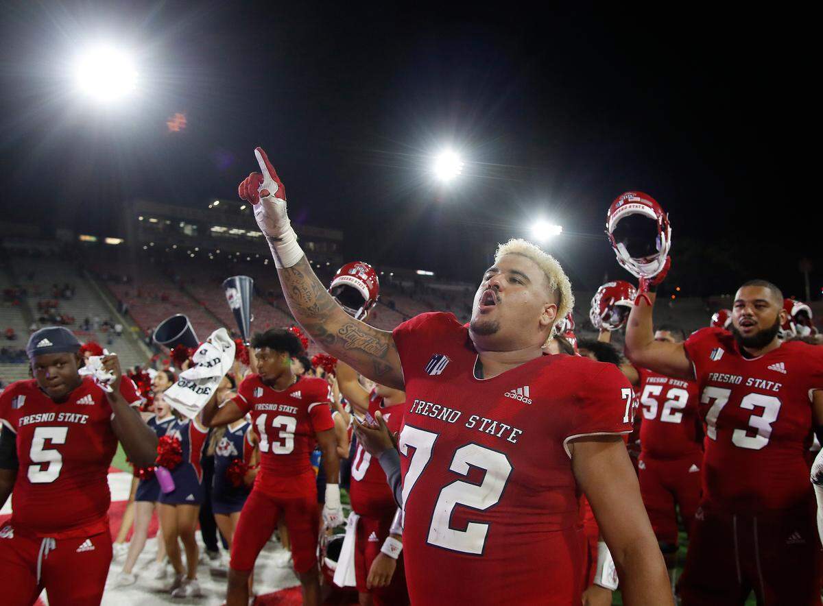 Fresno State offensive lineman Dontae Bull, foreground, celebrates a win over Nevada in 2021.
