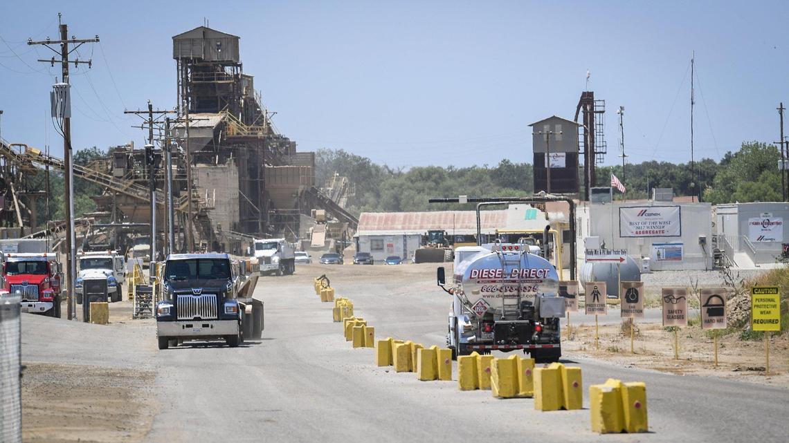 Trucks come and go at the entrance to the CEMEX Rockfield aggregate plant site in Friant on Wednesday, June 17, 2020. The company applied to Fresno County to continue mining the quarry for 100 years, and use blasting and drilling to mine a 600-ft deep pit.